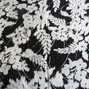 Fabric with white flower and fern patternon a black background